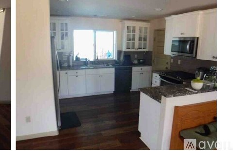 A kitchen with white cabinets and a black stove top.