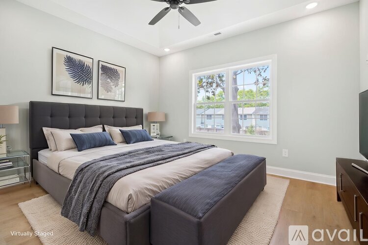 A bedroom with a large bed and a ceiling fan.