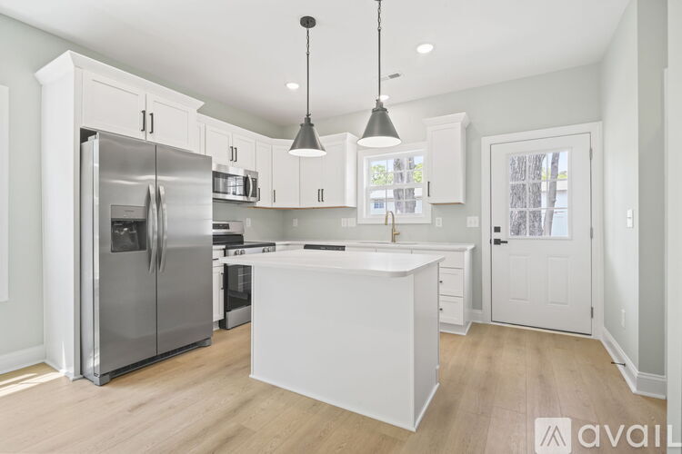 A modern kitchen with white cabinets and a central island.