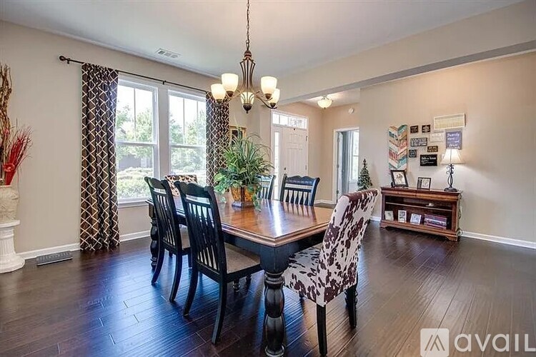 A dining room with a table and chairs.