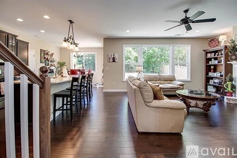 A living room with a white couch and a ceiling fan.