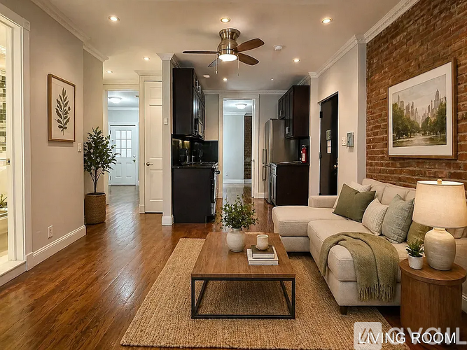 A living room with a couch, a coffee table, and a ceiling fan.