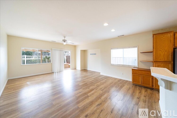 A spacious room with wooden flooring and white walls.