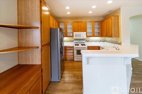A kitchen with wooden cabinets and a white countertop.