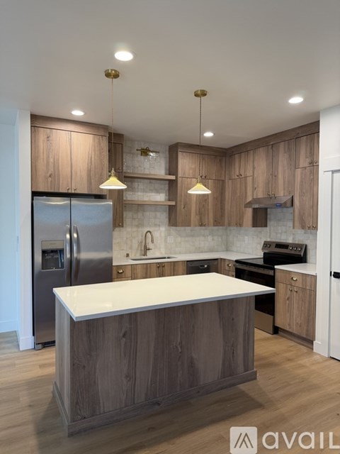 A modern kitchen with wooden cabinets and stainless steel appliances.
