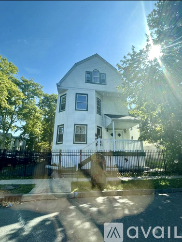 A white house with a black fence in front of it.