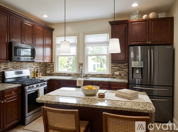 A kitchen with a granite countertop and stainless steel appliances.