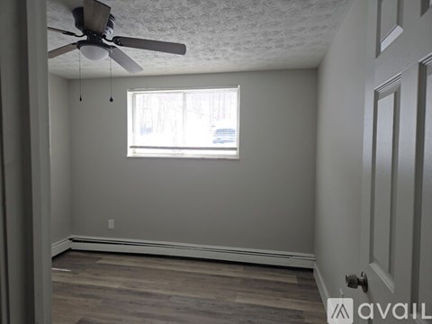 A room with a ceiling fan and a window.