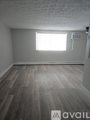 A room with wooden flooring and a window.