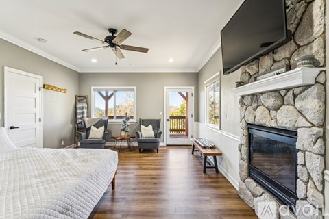 A living room with a fireplace and a television mounted on the wall.