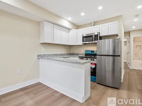 A kitchen with white cabinets and a granite countertop.