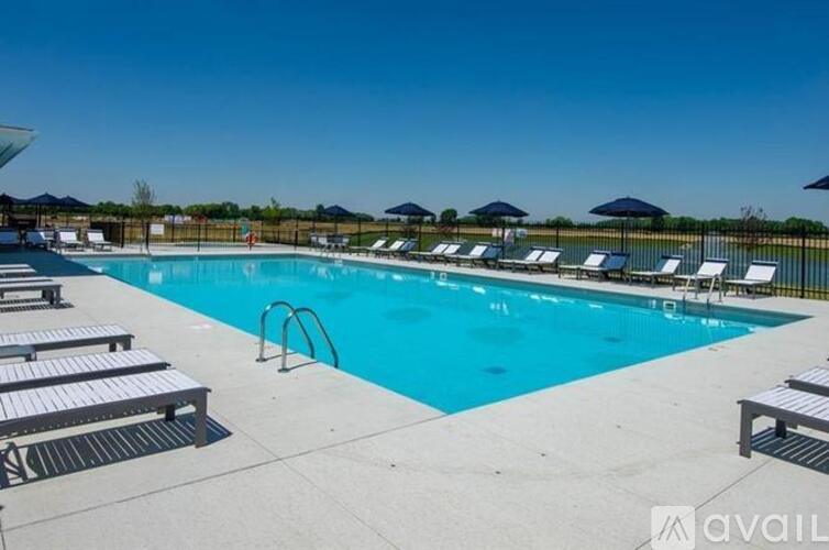 A large outdoor swimming pool with sun loungers and umbrellas.