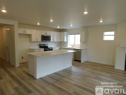 A kitchen with a white island in the middle of the room.