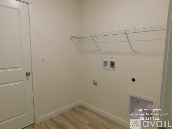 A white door is on the left side of the image with a white wall and a white shelf above it.