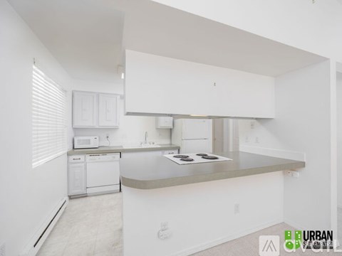 A white kitchen with a stove top oven and a microwave.