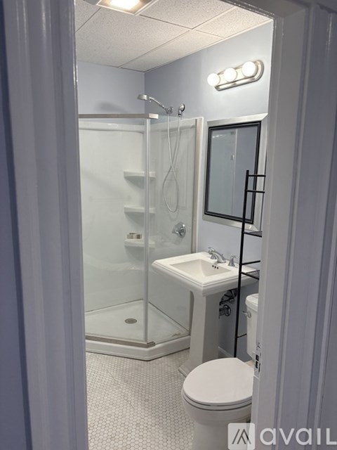 A bathroom with a toilet, sink, and shower.