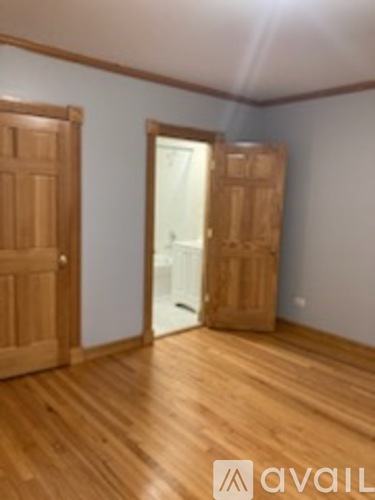 A room with wooden floors and two doors.