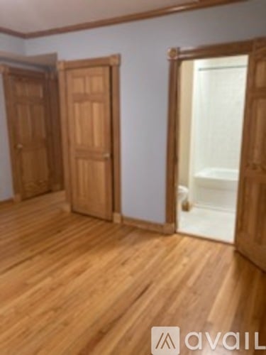 A room with wooden floors and two doors.