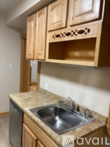 A kitchen with wooden cabinets and a granite countertop.
