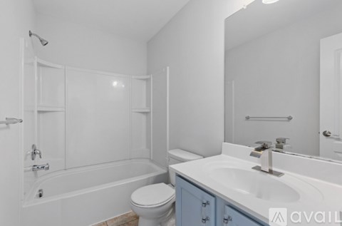 A white bathroom with a toilet, sink, and bathtub.