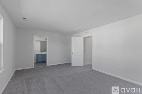A room with a carpeted floor and two doors.