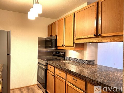 A kitchen with wooden cabinets and granite countertops.