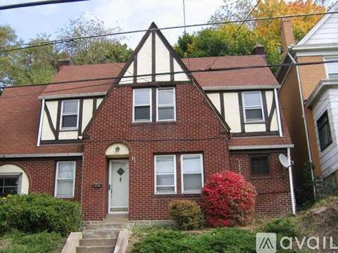 A house with a red brick facade and white trim.
