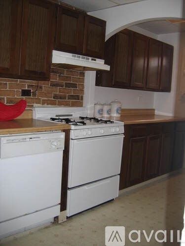 A kitchen with a white stove and a white dishwasher.