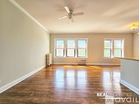 A spacious room with a ceiling fan and large windows.