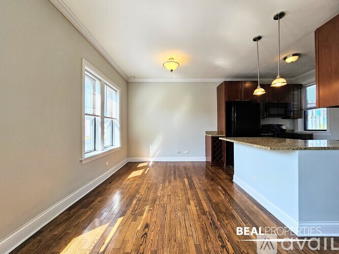 A spacious kitchen and living room with wood flooring and a large island.