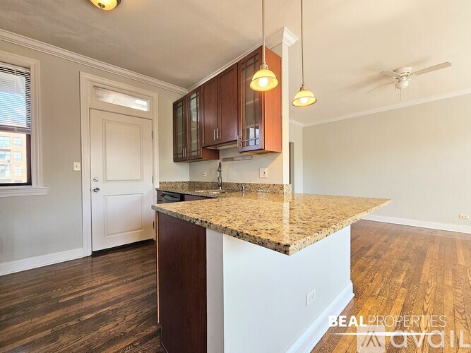 A kitchen with a granite countertop and wooden cabinets.