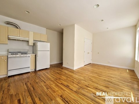 A kitchen with wooden floors and white appliances.