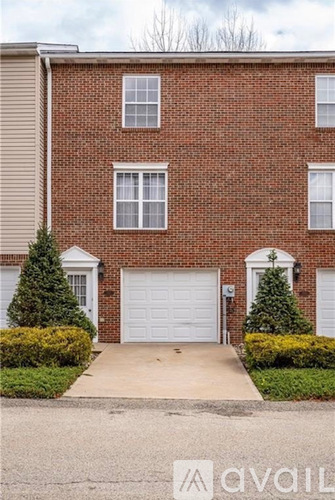 A red brick house with a white garage door.