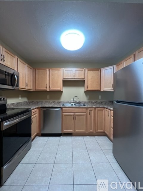 A kitchen with wooden cabinets and a black oven.