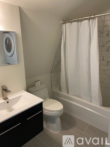 A bathroom with a toilet, sink, and shower.