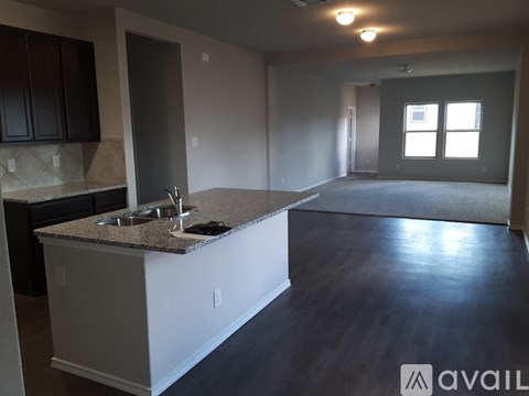 A kitchen with a granite countertop and a sink is available for rent.