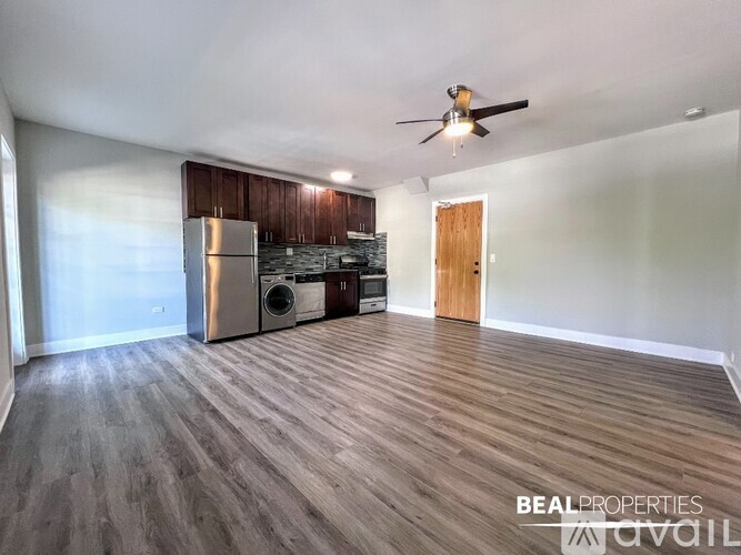 A spacious room with a wooden floor and a ceiling fan.