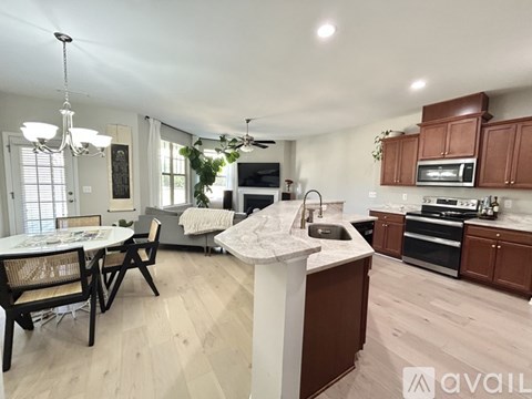 A well-lit kitchen with wooden floors and a dining table set for two.