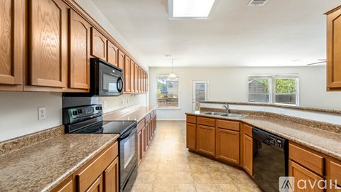 A kitchen with brown cabinets and black appliances.