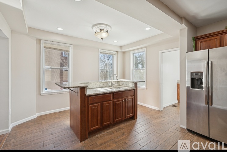 A kitchen with a refrigerator on the right side.
