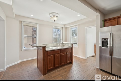 A kitchen with a refrigerator on the right side.