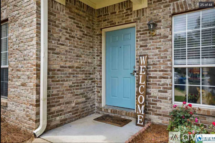A house with a blue door and a welcome sign.