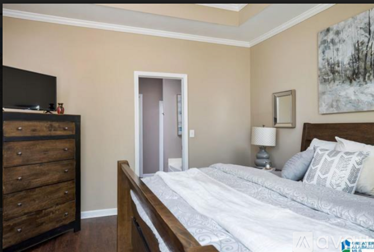 A bedroom with a bed, dresser, and painting.
