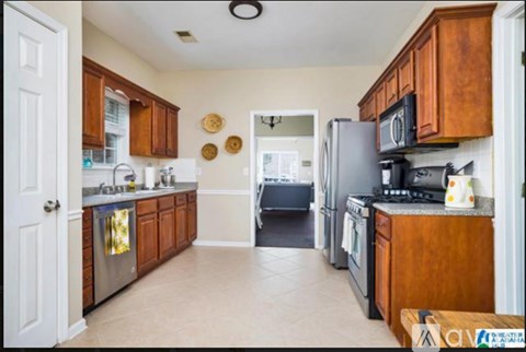 A kitchen with wooden cabinets and a black refrigerator.