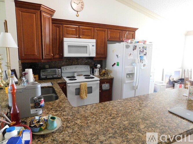 A kitchen with granite countertops and a white refrigerator.