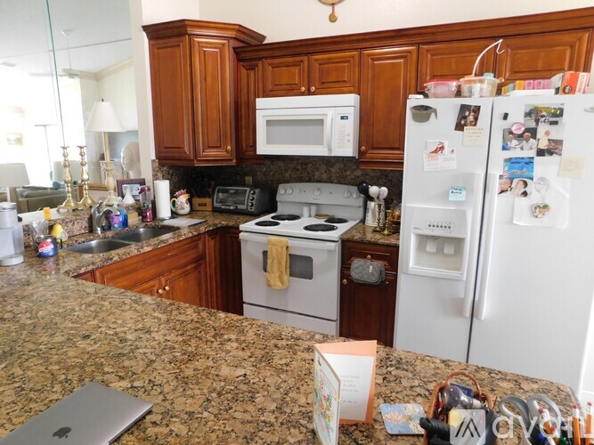 A kitchen with granite countertops and a white refrigerator.