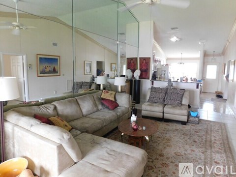 A living room with a couch, a coffee table, and a painting on the wall.