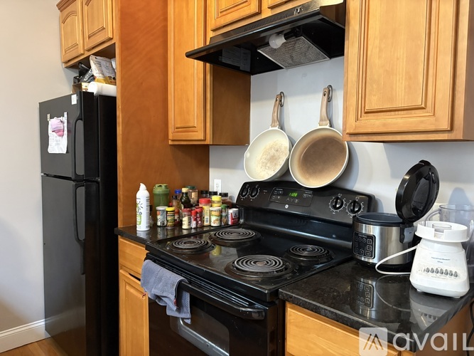 A kitchen with a black stove top and wooden cabinets.