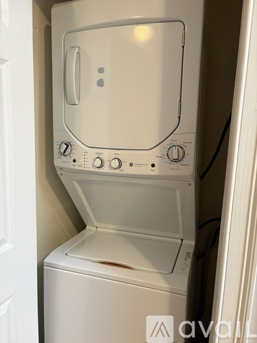 A white dryer and washer are sitting in a small space.