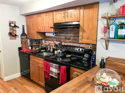 A kitchen with wooden cabinets and a brick backsplash.